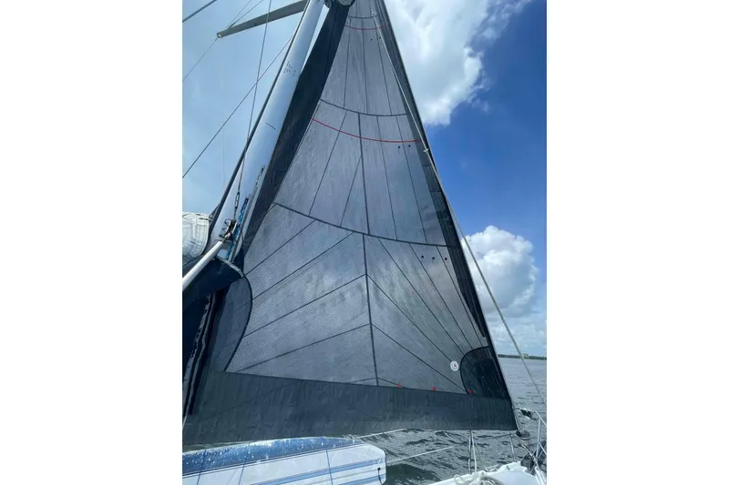 Slide: The Image of Sailboat with black sail on water, Hunter 410 model, 2000, under blue sky. - 62