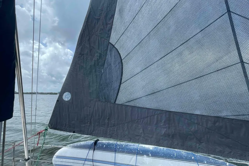 Slide: The Image of Sailboat with black sail on water, Hunter 410 model, 2000, under cloudy sky. - 63