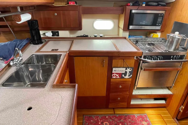Slide: The Image of Compact kitchen in a 2000 Hunter 410 yacht with stove, sink, and microwave. - 7