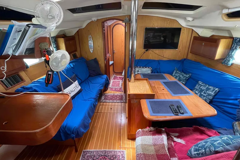 Slide: The Image of Interior of a 2000 Hunter 410 sailboat with cozy seating and wooden furnishings. - 9