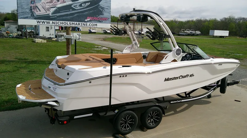Slide: The Image of 2026 MasterCraft NXT24 boat on trailer, ready for watersports. - 5