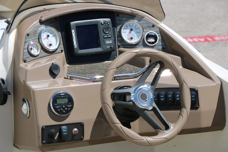 Slide: The Image of Dashboard of a 2015 Stingray 192 SC boat with steering wheel and instruments. - 24