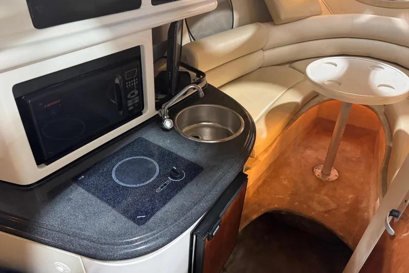 Slide: The Image of Interior of a 2005 Monterey 250 Cruiser boat with kitchenette and seating area. - 12