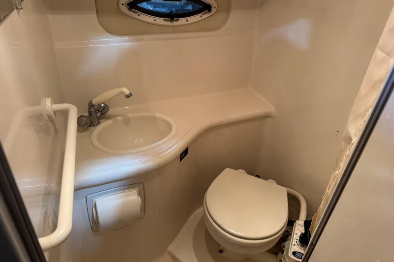 Slide: The Image of Compact bathroom in a 2005 Monterey 250 Cruiser boat, featuring a sink and toilet. - 14