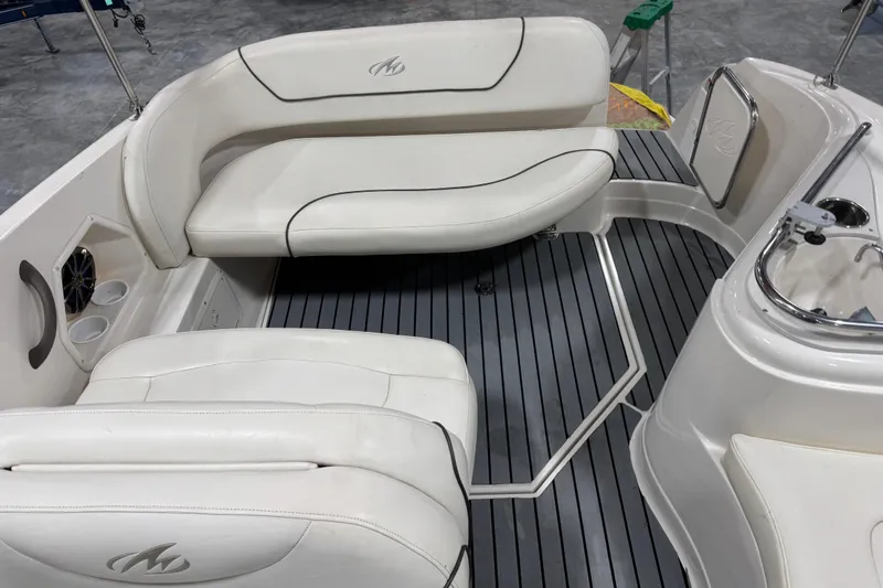 Slide: The Image of 2005 Monterey 250 Cruiser interior with white seating and gray flooring. - 8