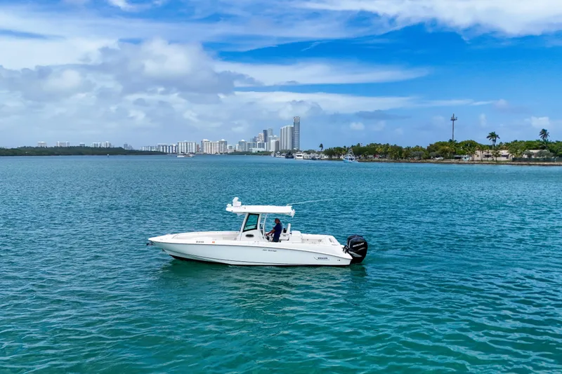 The Image of 2013 Boston Whaler 320 Outrage boat on calm water with city skyline in background. - 1