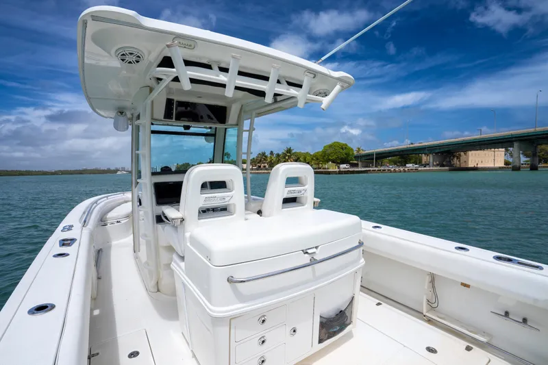 Slide: The Image of 2013 Boston Whaler 320 Outrage boat on water near a bridge under blue sky. - 11