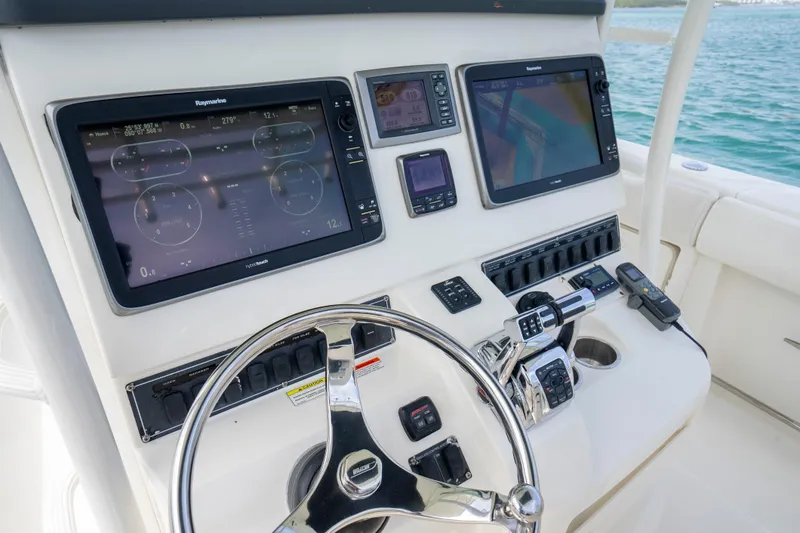 Slide: The Image of Control panel of a 2013 Boston Whaler 320 Outrage with navigation screens and steering wheel. - 14