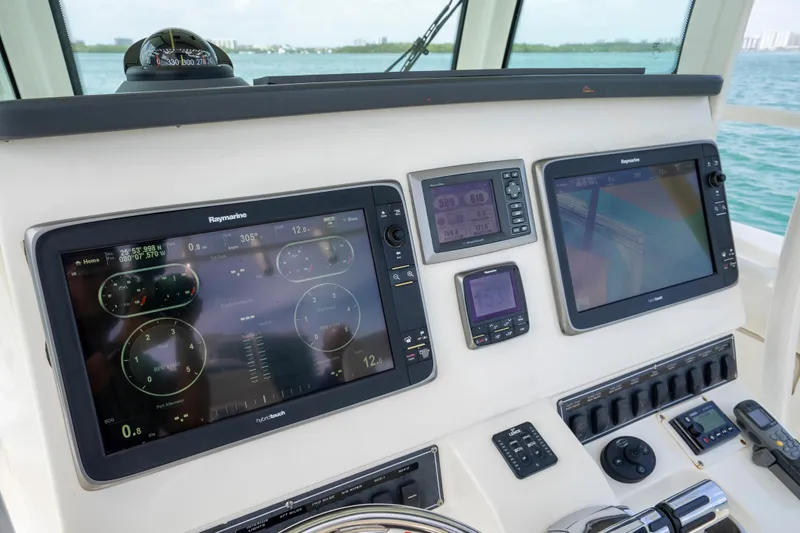 Slide: The Image of 2013 Boston Whaler 320 Outrage helm with Raymarine navigation displays and controls. - 15