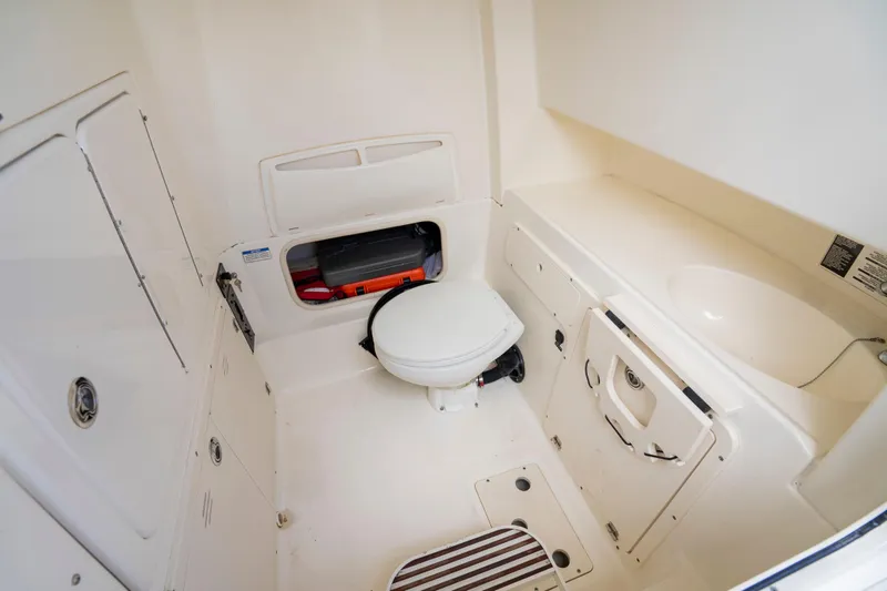 Slide: The Image of Interior of 2013 Boston Whaler 320 Outrage boat, featuring a compact marine toilet. - 20
