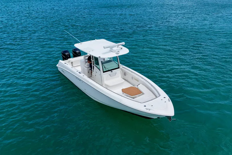 Slide: The Image of 2013 Boston Whaler 320 Outrage boat on clear blue water, showcasing sleek design. - 5