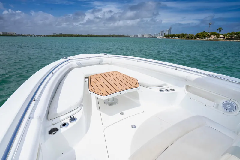 Slide: The Image of 2013 Boston Whaler 320 Outrage boat interior with seating and table on calm water. - 9