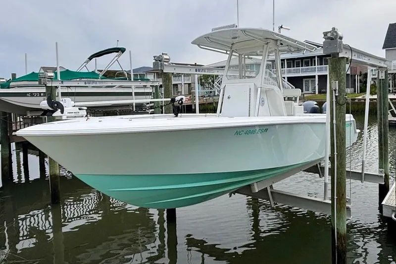 The Image of 2018 Contender 25 Tournament boat on lift, docked near waterfront homes. - 0
