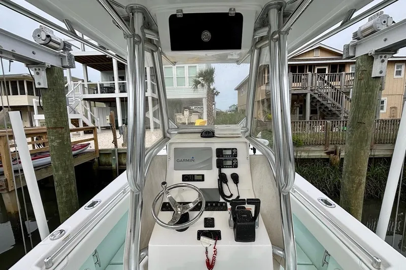 Slide: The Image of 2018 Contender 25 Tournament boat console with Garmin navigation, docked near waterfront homes. - 10