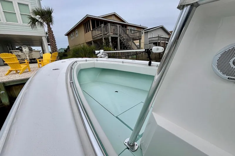 Slide: The Image of 2018 Contender 25 Tournament boat docked near coastal homes with yellow chairs. - 11