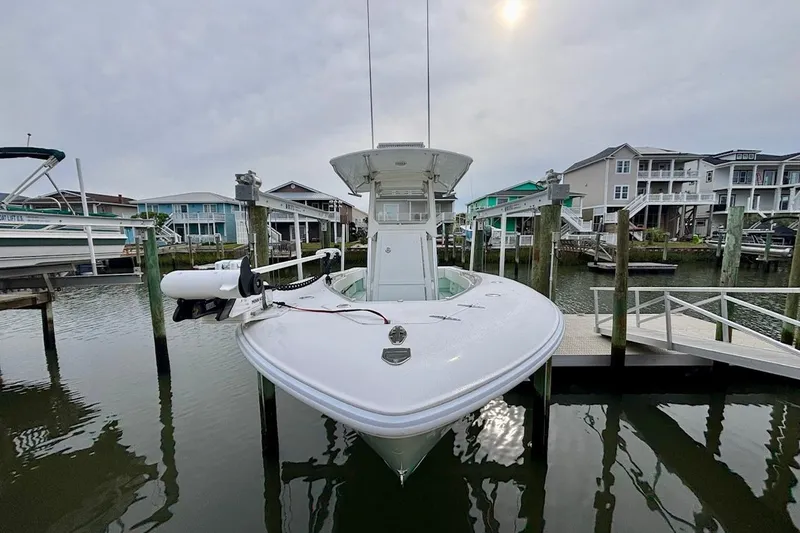 Slide: The Image of 2018 Contender 25 Tournament boat docked in a marina with waterfront homes. - 2