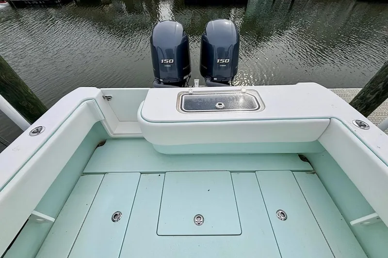 Slide: The Image of 2018 Contender 25 Tournament boat with twin 150 horsepower engines, docked by the water. - 9