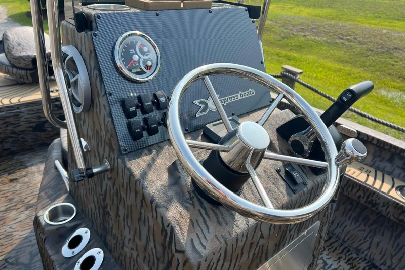 Slide: The Image of Steering console of 2025 Xpress H20B Bay boat with chrome wheel and controls. - 11