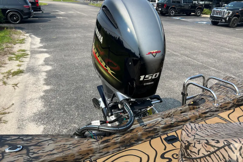 Slide: The Image of 2025 Xpress H20B Bay boat with Yamaha 150 engine in parking lot. - 14