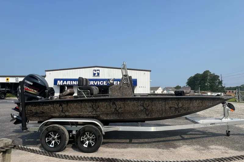 Slide: The Image of 2025 Xpress H20B Bay boat on trailer at marine service center. - 4
