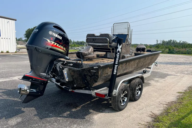 Slide: The Image of 2025 Xpress H20B Bay boat with Yamaha engine on a trailer in a parking lot. - 6