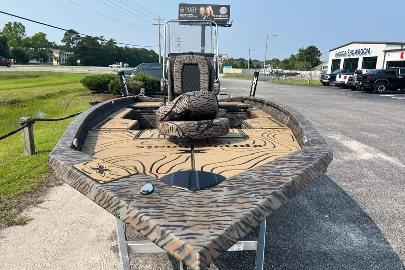Slide: The Image of 2025 Xpress H20B Bay boat with camouflage design on display outdoors. - 7