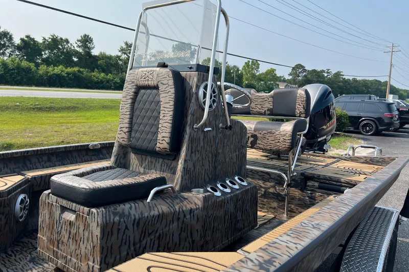 Slide: The Image of 2025 Xpress H20B Bay boat with camo design, featuring a sleek console and seating. - 9