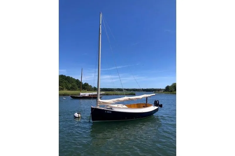 The Image of Vintage 1978 Marshall Sanderling sailboat moored on a serene lake under clear blue skies. - 0