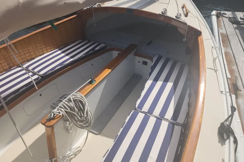 Slide: The Image of 1978 Marshall Sanderling sailboat interior with striped cushions and wooden trim. - 2