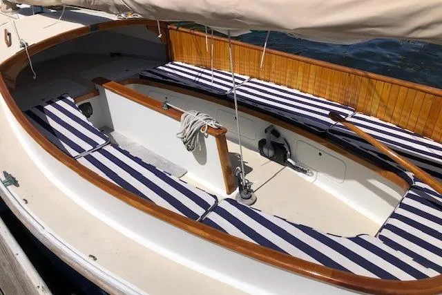 Slide: The Image of 1978 Marshall Sanderling sailboat with striped cushions and wooden trim on a sunny day. - 3