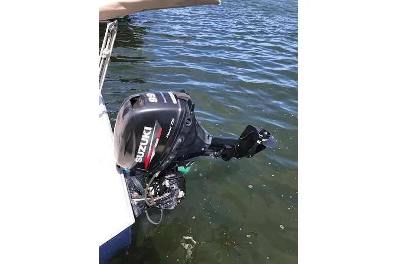 Slide: The Image of Outboard motor on a 1978 Marshall Sanderling sailboat, floating on calm water. - 9