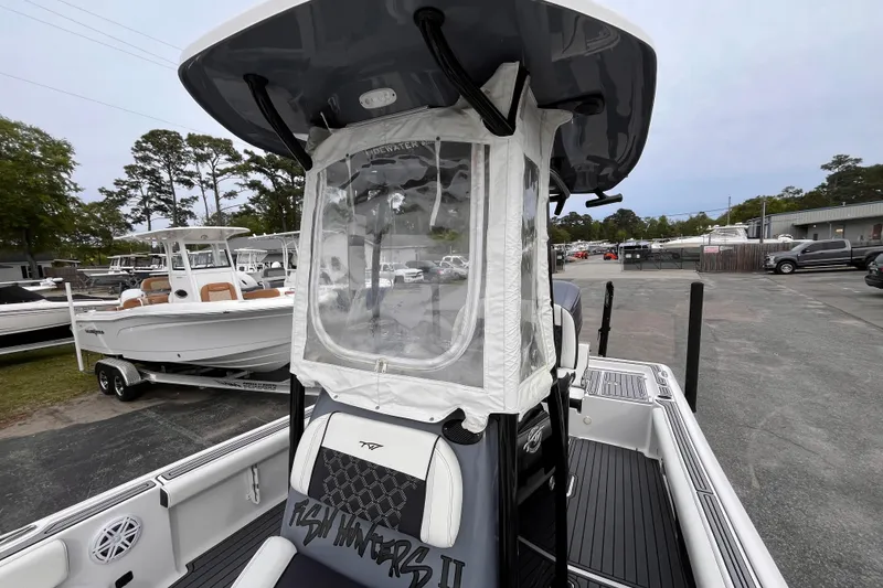 Slide: The Image of 2021 Tidewater 2300 Carolina Bay boat with T-top enclosure, parked in a marina. - 11