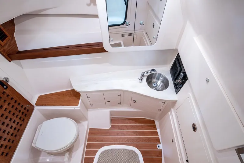 Slide: The Image of Manufacturer Provided Image: 2023 Grady-White Freedom 335 boat bathroom with sink, toilet, and wooden accents. - 15
