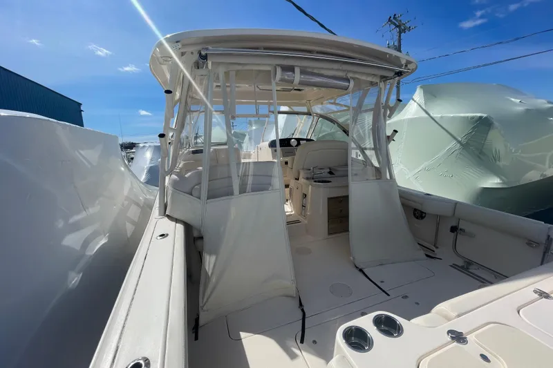 Slide: The Image of 2023 Grady-White Freedom 335 boat interior with seating and helm, under clear blue sky. - 25