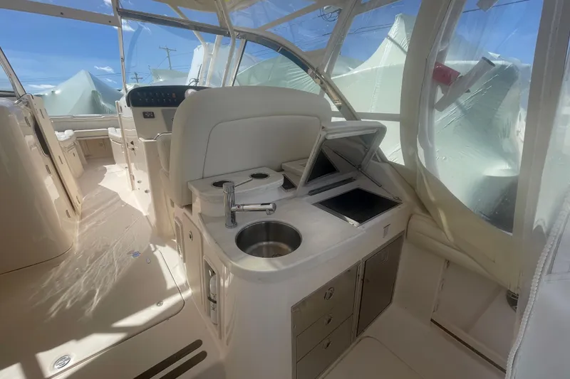 Slide: The Image of 2023 Grady-White Freedom 335 boat interior with kitchenette and helm, featuring modern amenities. - 27