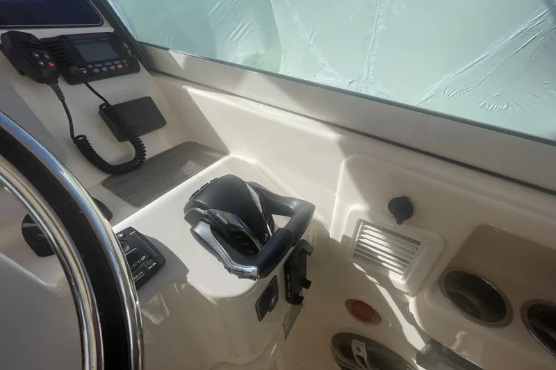 Slide: The Image of Control panel of 2023 Grady-White Freedom 335 boat with steering wheel and communication equipment. - 39