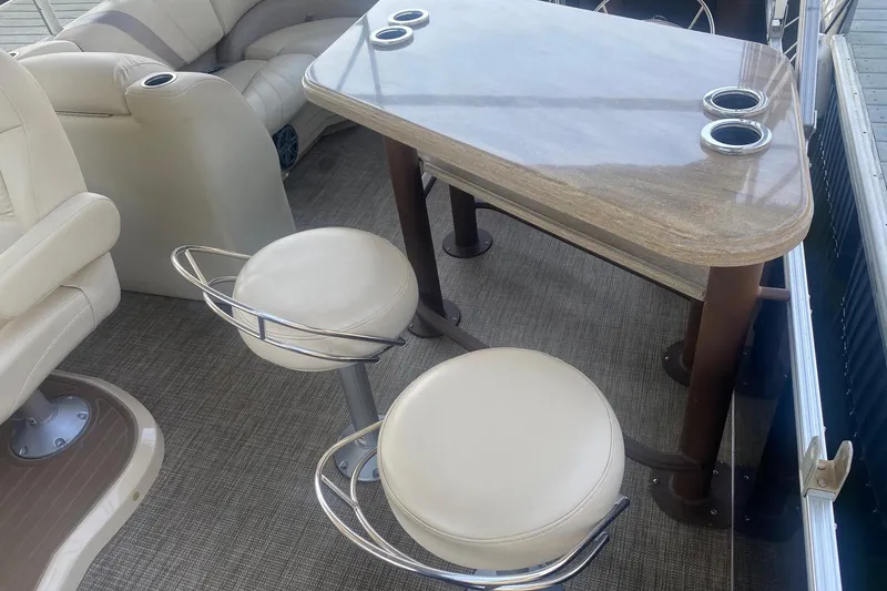 Slide: The Image of Interior of 2017 Sylvan Mirage Cruise 8524 LZ PB with seating and table setup. - 8