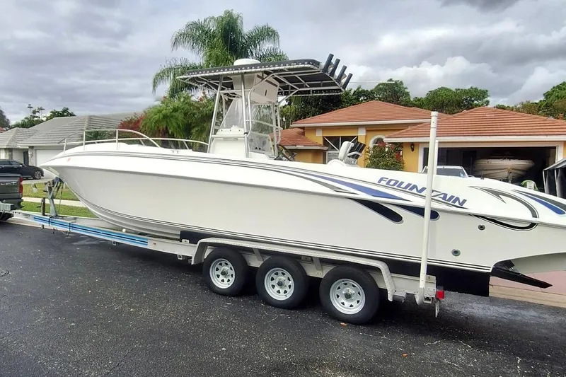 The Image of 2001 Fountain 31 Tournament Edition boat on trailer, parked in residential driveway. - 0