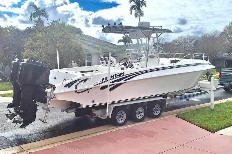 Slide: The Image of 2001 Fountain 31 Tournament Edition boat on trailer, parked in residential area. - 2