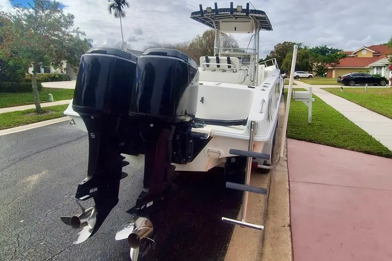 Slide: The Image of 2001 Fountain 31 Tournament Edition boat with dual outboard motors parked on a residential street. - 3