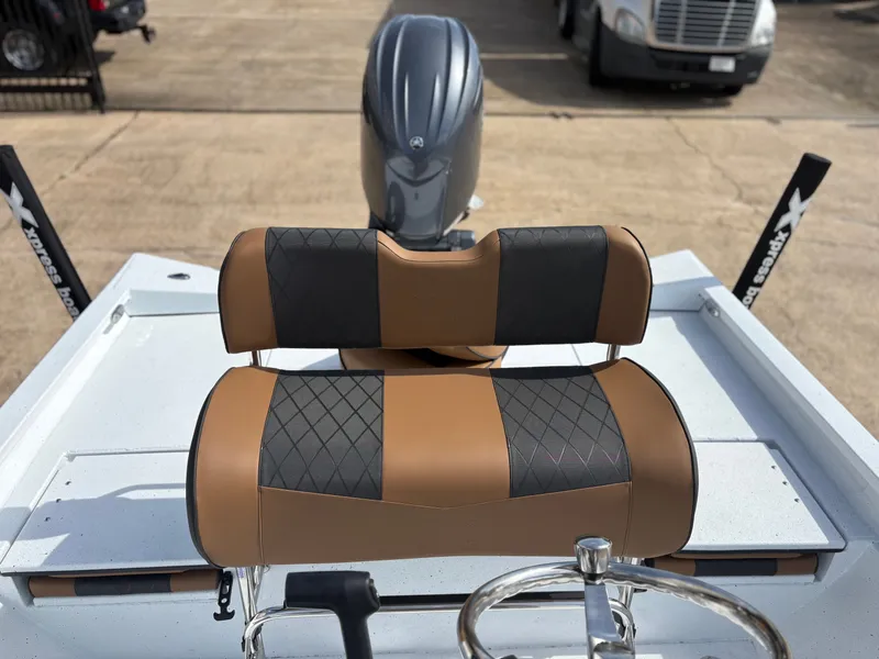 Slide: The Image of Xpress H22B boat with brown-black seat and outboard motor. - 5