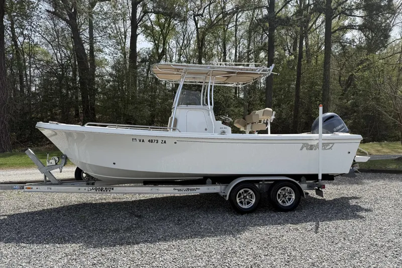 The Image of 2019 Parker 23 Special Edition boat on trailer, parked outdoors, surrounded by trees. - 0