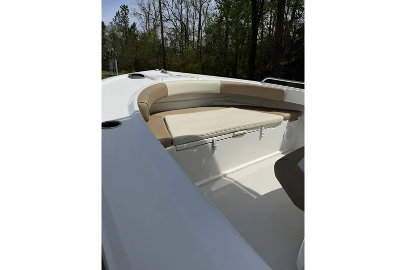 Slide: The Image of 2019 Parker 23 Special Edition boat with cushioned seating, set against a wooded backdrop. - 3