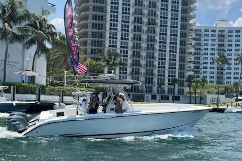 The Image of 1999 Hydra-Sports 3000 CC boat cruising near waterfront buildings and palm trees. - 0