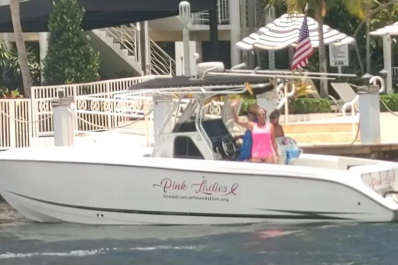 Slide: The Image of 1999 Hydra-Sports 3000 CC boat with passengers, docked near a waterfront property. - 21