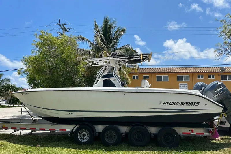 Slide: The Image of 1999 Hydra-Sports 3000 CC boat on trailer, parked outdoors under clear blue sky. - 3