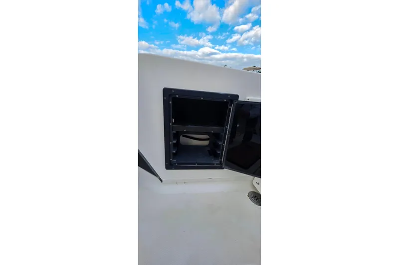 Slide: The Image of Open storage compartment on 1999 Hydra-Sports 3000 CC boat under a blue sky. - 8