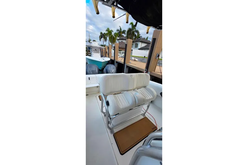 Slide: The Image of 1999 Hydra-Sports 3000 CC boat interior with white seating and dock view. - 9