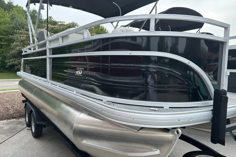 The Image of 2026 Sun Tracker Fishin' Barge 20 DLX pontoon boat on trailer, side view. - 0