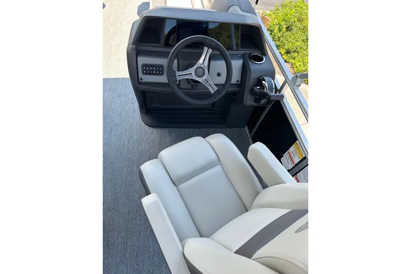 Slide: The Image of 2026 Sun Tracker Fishin' Barge 20 DLX helm with steering wheel and comfortable seating. - 7